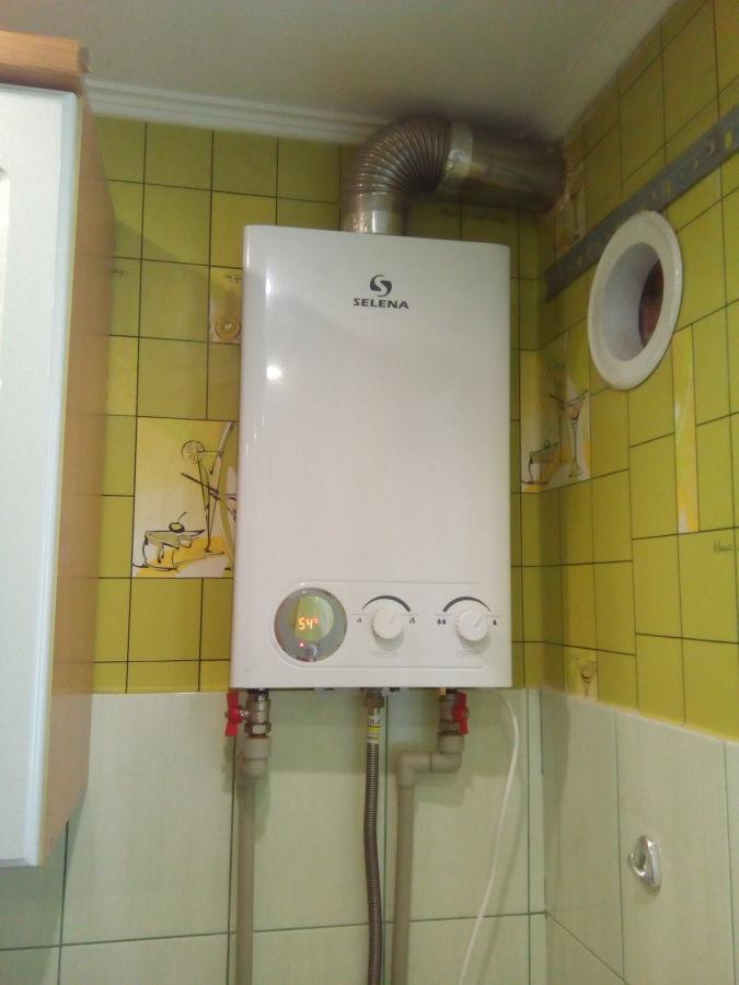газовая колонка на фоне плитки